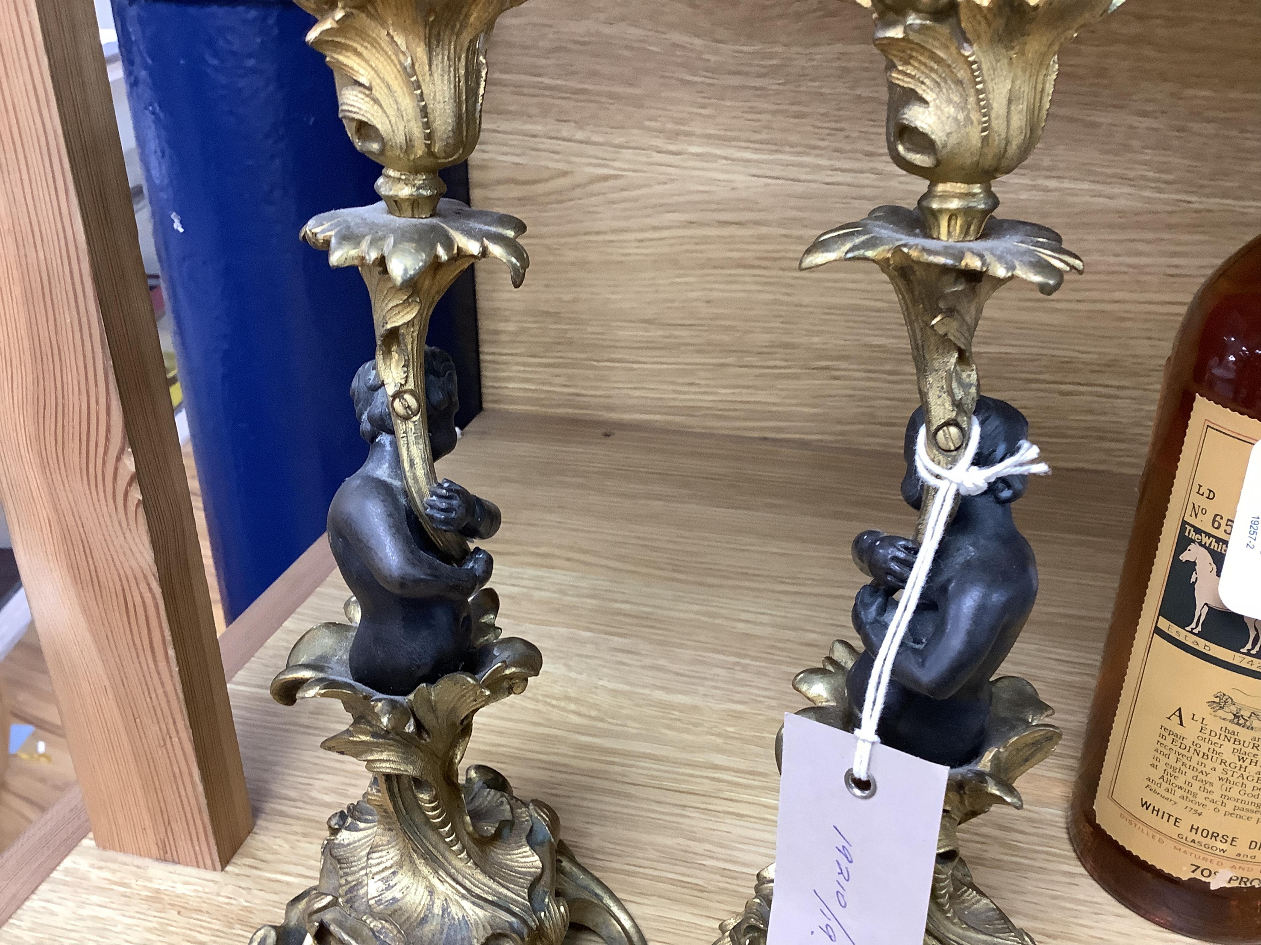 A pair of decorative French ormolu figural candlesticks, 25.5cm high